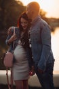 Lovely parents standing near lake and posing together