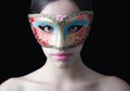 Beautiful pale girl with costume ball mask on her face