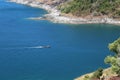 A beautiful panorama day shot of a lonely long boat sailing to the beach in clear turquoise ocean waters with natural shore line