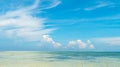 Beautiful panorama of horizon with hazy white tropical clouds above tropical blue empty sea.