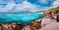 Beautiful panorama with impressive white fluffy clouds wild rocky beach Anse Marron in Seychelles. La Digue