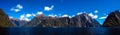 Beautiful panorama of Milford Sound with Mitre Peak on the foreground and snow capped mountains in the background taken on a sunny