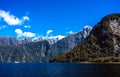 Beautiful panorama of Milford Sound with Mitre Peak on the foreground and snow capped mountains in the background taken on a sunny