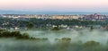 Beautiful panorama of morning aerial view of Ivano-Frankivsk city, Ukraine. Scene of quiet suburbs among green trees under dense f Royalty Free Stock Photo