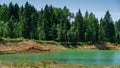 Beautiful panorama of quarry lake with emerald green water and big forest as background. Closed down quarry now is bathing plac Royalty Free Stock Photo