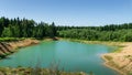 Beautiful panorama of quarry lake with emerald green water and big forest as background. Closed down quarry now is bathing place Royalty Free Stock Photo