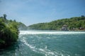 Beautiful panorama view of big river under the waterfall with fresh green trees and blue sky Royalty Free Stock Photo