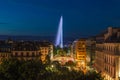 Beautiful panorama view of illuminated Geneva Water Fountain Jet d`Eau landmark at dusk with blue sky, Geneva, Switzerland