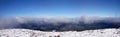 A beautiful panorama view of the snow-capped mountains of the Carpathians from the top of Goverly in spring in a beautiful sunny