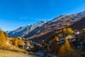 Beautiful panorama view of Zermatt town in the vally with snow covered peaks of Swiss Alps in background and golden trees forest