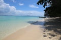 Beautiful panorama wallpaper shot of a paradisiac white sand beach with crystal clear turquoise ocean water, deep blue sky with Royalty Free Stock Photo