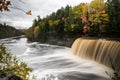 Beautiful panoramic autumn photograph of Upper Tahquamenon Falls in Michigan with water cascading into the river below surrounded Royalty Free Stock Photo