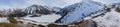 Beautiful panoramic mountains landscape with frozen lake in sunny winter day.