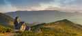 Beautiful panoramic mountains landscape in spring. Springtime in mountains. View of forested hills and grassy slopes illuminated