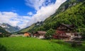Beautiful panoramic postcard view of picturesque rural mountain scenery in the Alps with traditional old alpine mountain chalets