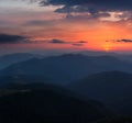 Beautiful panoramic sunset in the mountains landscape. Dramatic evening sky. Green hills covered by forest. Royalty Free Stock Photo