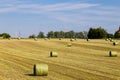 Beautiful panoramic view of afield with straw bales and a blue sky with clouds