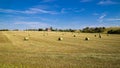 Beautiful panoramic view of afield with straw bales and a blue sky with clouds