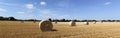 Beautiful panoramic view of afield with straw bales and a blue sky with clouds