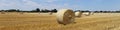 Beautiful panoramic view of afield with straw bales and a blue sky with clouds