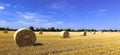 Beautiful panoramic view of afield with straw bales and a blue sky with clouds