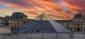 Beautiful panoramic view of the Louvre museum in Paris with its buildings and pyramids on the banks of the Seine river at sunset Royalty Free Stock Photo