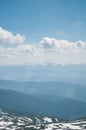 A beautiful view of the snow-capped mountains of the Carpathians from the top of Goverly in spring in a beautiful sunny