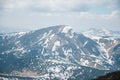 A beautiful view of the snow-capped mountains of the Carpathians from the top of Goverly in spring in a beautiful sunny