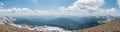 A beautiful panoramic view of the snow-capped mountains of the Carpathians from the top of Goverly in spring in a beautiful sunny