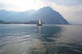 Lake Como at Lecco with sailboat moving away from the city.