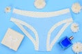 Beautiful panties with bottle of perfume and gift box on blue and white background. Women underwear set.
