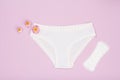 Beautiful women`s panties with a sanitary napkin on lilac background