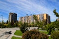 Beautiful park against tall houses, buildings. skyscrapers landscape. Spring, summer street in Ukrainian city Dnipro Ukraine Royalty Free Stock Photo