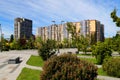 A beautiful park against tall houses, buildings and skyscrapers, landscape. Spring, summer street in Ukrainian city Dnipro, Royalty Free Stock Photo