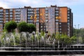 A beautiful park with fountains and trees against backdrop of tall houses, buildings and skyscrapers. Urban landscape. Spring, Royalty Free Stock Photo