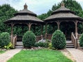 Twin brown wooden gazebos in city park