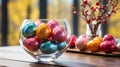 Beautiful pastel-painted Easter eggs in a glass vase, spring flowers on the table Royalty Free Stock Photo