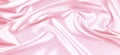 Beautiful pastel pink background with drapery and wavy folds of silk satin material texture. Top view Royalty Free Stock Photo