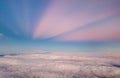 Beautiful pastel sky atmosphere over white puffy cloud before sunset as seen through window of airplane, plane window.