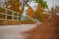 Beautiful path with blue guardrail in autumn next to Drava river in Maribor. Fall setting next to a river, lonely cold day