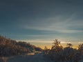 Beautiful path on the top of the mountain covered with snow and the sun setting in the sky Royalty Free Stock Photo