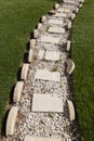 Beautiful path of white stones on a lawn of green grass. Royalty Free Stock Photo