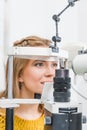beautiful patient examining her eyes with slit lamp