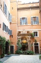 Beautiful patio with a fountain,statues and greenery in a building in central Rome, Italy.