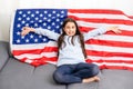 Beautiful patriotic little girl with the American flag held in her outstretched hands Royalty Free Stock Photo