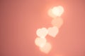 Beautiful pattern from flying bokeh sparkling garland lights in heart shape on pastel pinkish background. Valentine romantic love Royalty Free Stock Photo