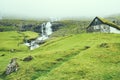 Beautiful peaceful rock house with green grass on the roof in Saksun valley next to the waterfall in foggy weather, Faroe Islands Royalty Free Stock Photo