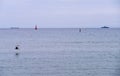 Beautiful peaceful seascape with small ship and lighthouse silhouette on the sea horizon Royalty Free Stock Photo