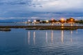 Beautiful and peaceful sunset over the small sea harbour with blue clouds and lights reflection in the water Royalty Free Stock Photo