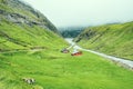 Beautiful peaceful wooden house in Saksun valley with green grass next to the river in foggy weather, Faroe Islands, North Europe Royalty Free Stock Photo